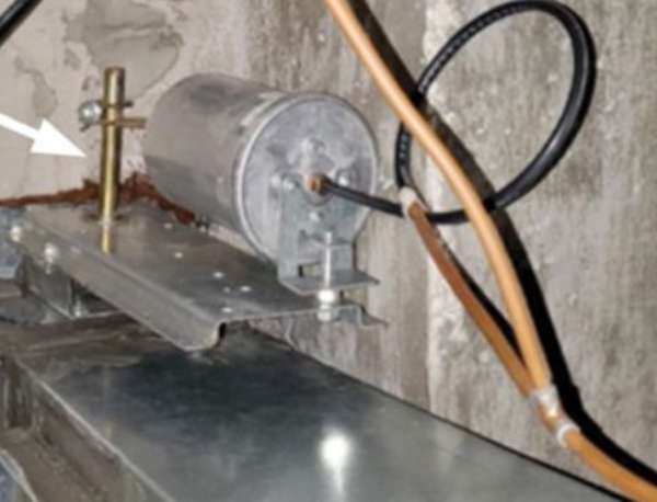 Photo D. Typical external actuator installation. The electric actuator is direct-coupled to the damper shaft, while the old mounting plate serves as an anti-rotation strap.